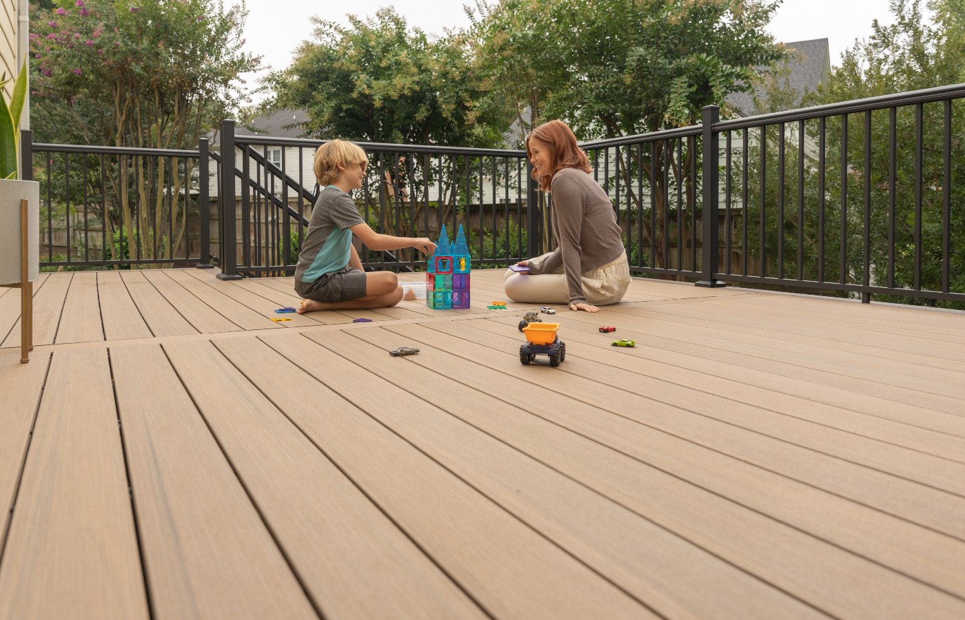 A person and a child playing with toys on a deck

Description automatically generated